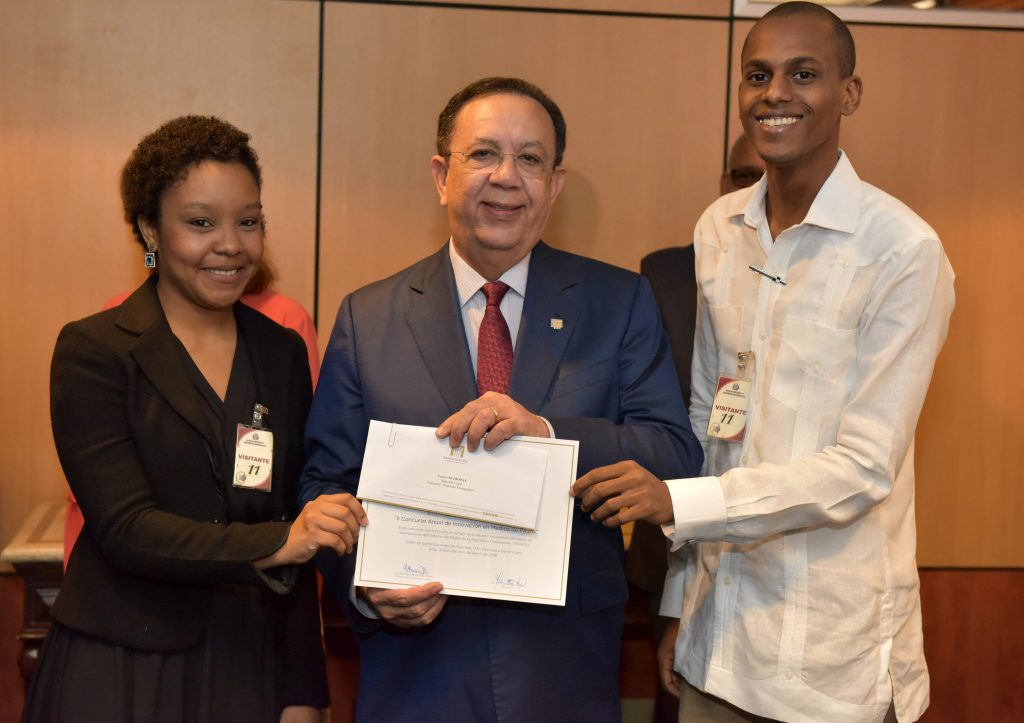 César Sena y Solange Jiménez reciben el premio de manos del Gobernador del Banco Central